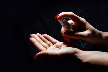 Mikrop, bakteri ve virüs yayılmasını önlemek için alkol spreyi ya da anti bakteri spreyi kullanan bir kadının eli. Kişisel hijyen kavramı.