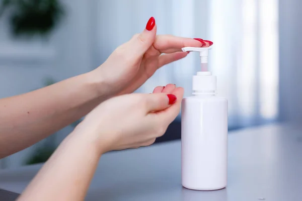 女人推着分配器 在手掌上挤出柔软的肥皂凝胶 在平坦的背景下近距离拍摄 用于洗手的透明液体肥皂 — 图库照片