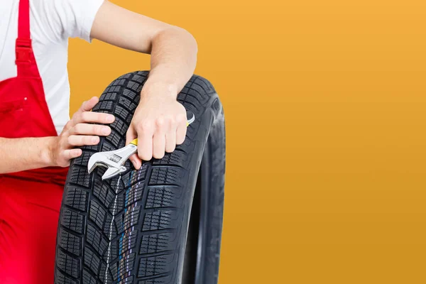 Automechaniker Trägt Reifen Auf Gelbem Hintergrund — Stockfoto