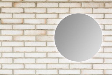 Tuğla duvarın yanındaki yuvarlak ayna