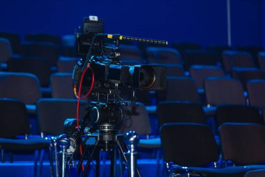 Profesyonel kamera, video kamera, mavi arkaplanda siyah kamera silueti.