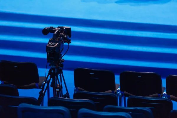 プロのビデオカメラ 三脚のビデオカメラ 青の背景に黒のシルエット — ストック写真
