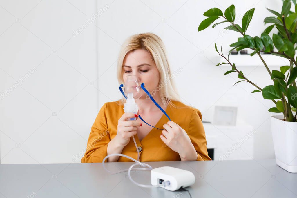 Young woman using nebulizer for asthma and respiratory diseases home