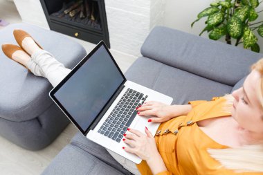 Tablet kullanan gülümseyen genç kadın.