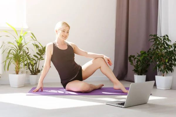 alone girl in medical mask doing yoga exercises on the floor in the light room during quarantine of covid 19 cotonavirus stay home