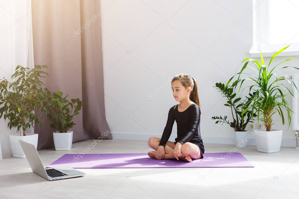 Home fitness. daughter do yoga online at home during self isolation quarantine. COVID-19 concept to promote stay safe home 