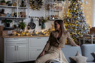 Genç, güzel ve rüya gibi sarışın bir kadının portresi Noel ağacının arka planında. Evin içi rahat. Yüksek kalite fotoğraf