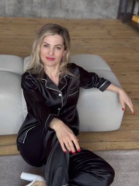 Günaydın konsepti. Siyah pijama giyen güzel, genç, seksi esmer kız, rahat yatak odasında beyaz yatakta tek başına yatar. Yüksek kalite fotoğraf