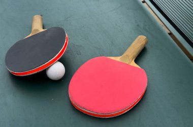 Beyaz top ile yeşil oyun masasında duran raketlerle profesyonel pinpon seti görüntüsü. Ön manzara. Yüksek kalite fotoğraf