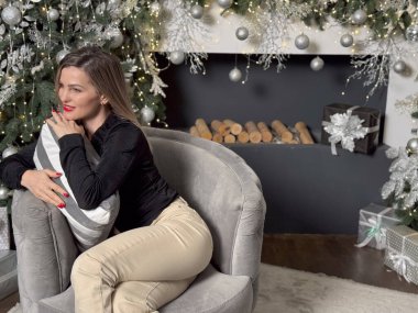 Neşeli, gülümseyen genç bir kadın evin sıcak bir iç odasında Noel tatili için hazırlanıyor. Yüksek kalite fotoğraf