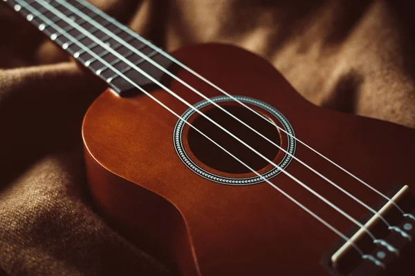 Close Foto Van Een Ukelele Tegen Een Bruine Achtergrond — Stockfoto