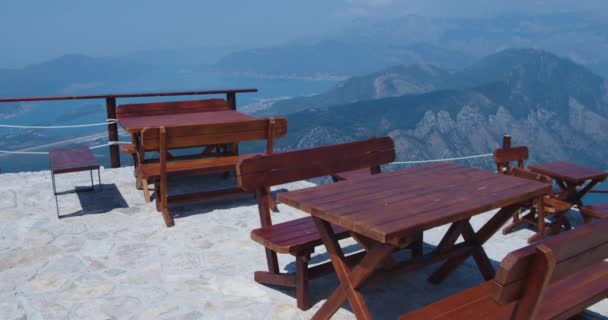 Street cafe στα βουνά με θέα τα βουνά και τον κόλπο. Ξύλινα τραπέζια και καρέκλες. — Αρχείο Βίντεο