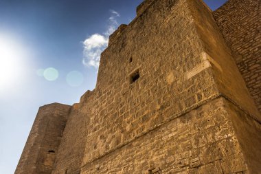 Parlak güneş üzerinde mavi gökyüzünde parlıyor antik kale taş duvarlar yıpranmış