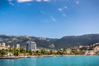 Güzel bir dağ sırtı ve parlak mavi gökyüzü karşı modern kıyı şehir manzarası 