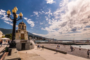 Tanınmayan insanlar küçük Şapel kıyısında deniz bulutlu gün sakin.