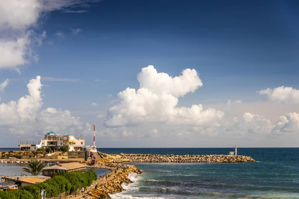 Kalın beyaz bulutlar üzerinde mavi gökyüzü güzel sakin deniz ve uzun taş iskele üzerinde yüzen