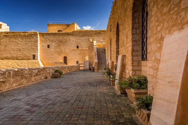 Yol yıpranmış taş duvarlar yaşlı kalenin bahçesinde yakınındaki güneşli günde açtı