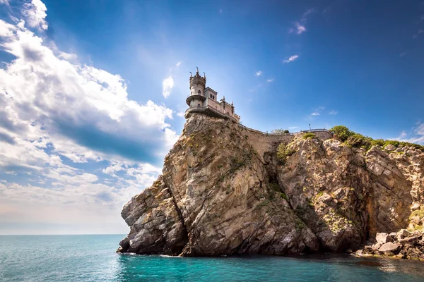 Bulutlu gökyüzü karşı sakin deniz kenarında kaba kayalık uçurum kenarında güneşli günde yer alan muhteşem eski kale