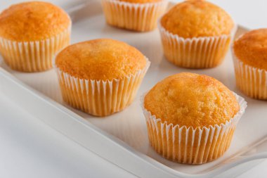 Hafif bir arka plan üzerinde beyaz bir tabakta cupcakes