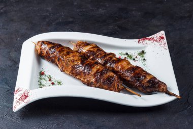 Sığır eti karaciğer üzerinde beyaz bir tabak içinde şişte sinirli bir mangal