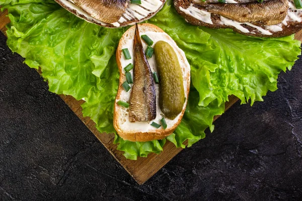Sandwiches Aus Sprotten Und Gurken Auf Salatblättern Und Holzbrettern — Stockfoto