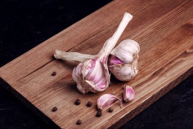 Tahtada iki baş sarımsak ve karabiber.