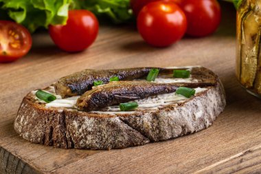 Çavdar ekmeğine basılmış bir sandviç dipte duruyor.