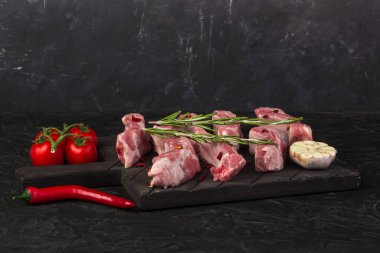 Biberiye, sarımsak, acı biber ve domatesli çiğ domuz pirzolası.