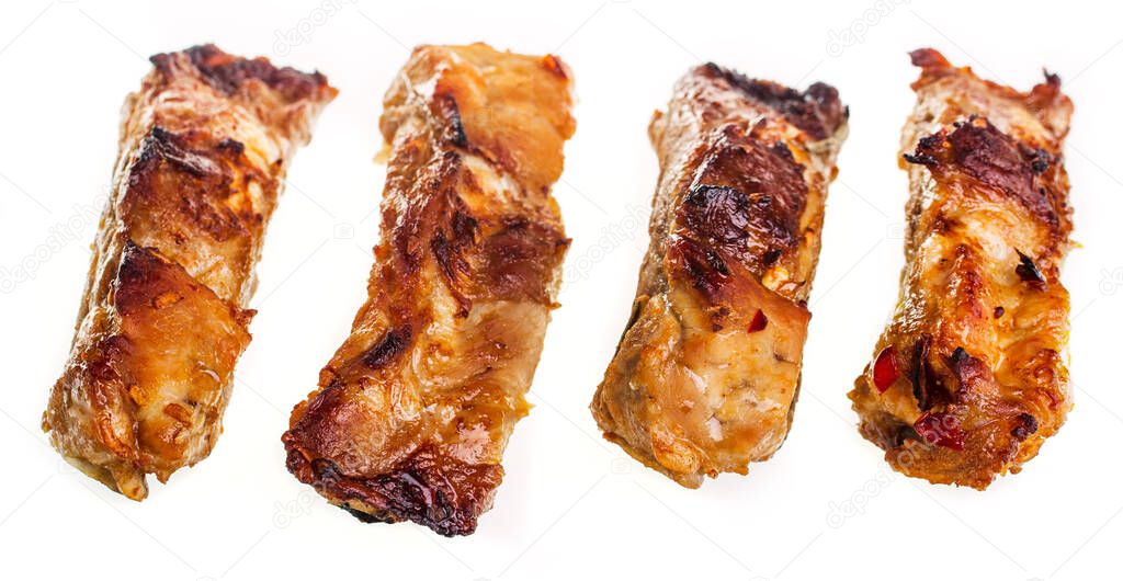 Sliced baked pork ribs on a white plate, isolate