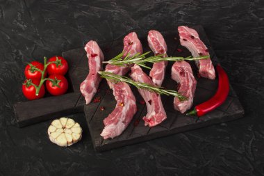 Biberiye, sarımsak, acı biber ve domatesli çiğ domuz pirzolası.