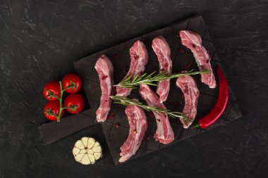 Biberiye, sarımsak, acı biber ve domatesli çiğ domuz pirzolası.