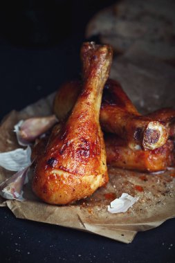 Ev yapımı tavuk drumsticks siyah arka plan üzerine sarımsaklı yakın çekim
