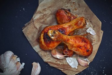 Ev yapımı tavuk drumsticks siyah arka plan üzerine sarımsaklı görünümü top