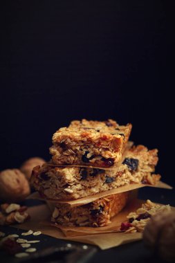 Ev yapımı granola barlar ile fındık ve kızılcık siyah arka plan üzerinde