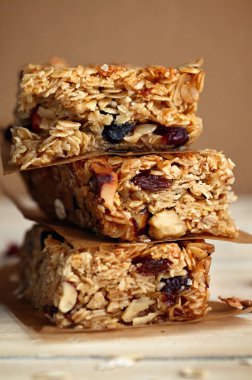 Ev yapımı granola barlar ile fındık ve kızılcık ahşap arka plan üzerinde