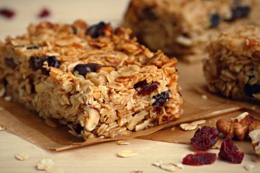 Ev yapımı granola barlar ile fındık ve kızılcık ahşap arka plan üzerinde
