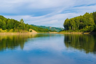 yeşil tepe ormanının ile kaplı çevrili geniş sakin Nehri ile manzara