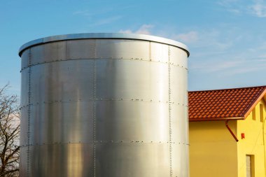 bir evin yanında yüklü büyük metal tank konteyner