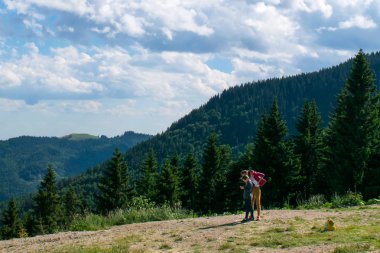 Sinaia, Prahova, Romanya - 29 Haziran 2019: Sinaia, Valea Prahovei 'deki akıllı telefon cihazına bakan kız ve erkek.