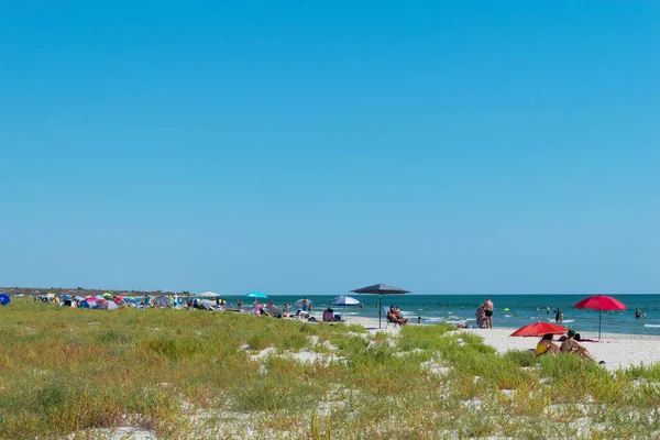 Corbu, Constanta, Romanya - 18 Ağustos 2019: İnsanlar Romanya 'nın Corbu kentindeki son bakir plajda rahatlatıcı bir yaz gününün tadını çıkarıyor