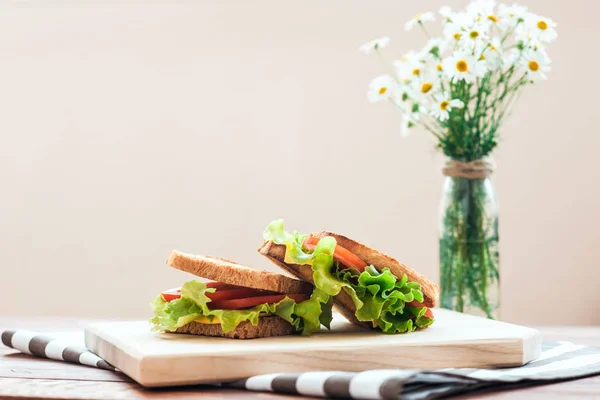 A wooden board with delicious breakfast with toast with vegetables on the table. Good breakfast