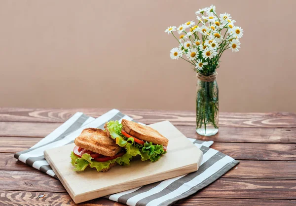 A wooden board with tasty breakfast toasts on the table