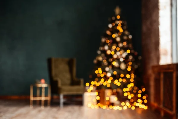Yeni yıl arka plan. Noel odası iç. Işık, hediyeler, mumlar ve sıcak iç aydınlatma. Hediyeler ile Noel ağacı yakınındaki bir tabloyla bir koltuk