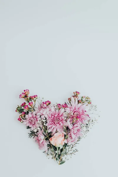 Heart in the form of full of various flowers. Flat lay. Love concept.