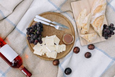 Şarap peyniri, üzüm ve baget. Piknikteki parktaki ahşap masada.