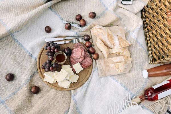 ピクニックの公園の木製テーブルの上のワインチーズ ブドウ バゲット — ストック写真
