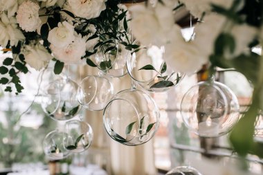 Beyaz çiçekli düğün dekoru ve mumlu cam şişeler.