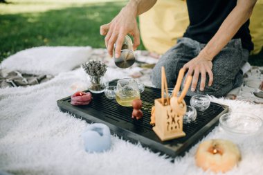 Çay seremonisinin ustası çayı demler ve çaydanlığa döker.
