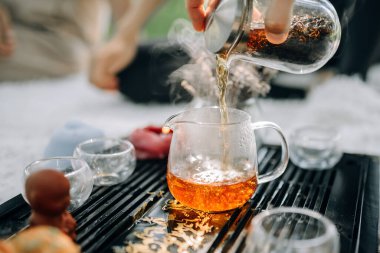 Çay demleme süreci. Çaydanlığa dökerken çay buharlaşır. Güneşli bir sabahta sokakta çay seremonisi, harika bir atmosfer..