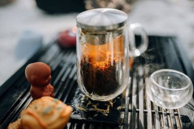 Cam çaydanlıkta demlenmiş kırmızı çay. Çay seremonisi sırasında güneş camdan bir çaydanlığın içinden parlar. Sabah çay seremonisinin güzel atmosferi.